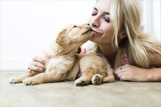 Owner kissing Golden Retriever puppy