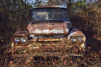 Abandoned rusty car in field