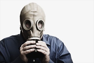 Studio shot of man trying to breath in gas mask