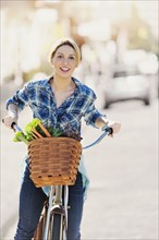 Portrait of young woman standing with bicycle.