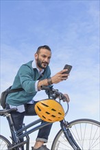 Man with bike using phone.