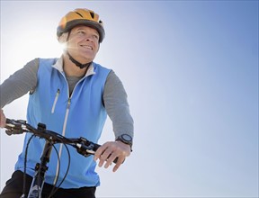 Man in cycling helmet on bike outdoors.
