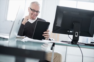 Man in office using tablet.