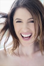 Portrait of beautiful woman with brown hair laughing.