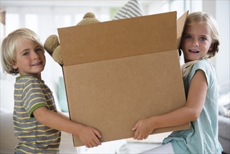 Boy (4-5) and girl (6-7) holding box