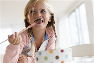 Girl (6-7) eating chocolate