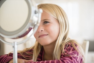 Girl (6-7) looking at vanity mirror