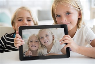 Sister (6-7) and brother (5-6) showing picture on digital tablet