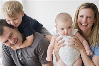 Portrait of parents with son (2-3) and baby daughter (12-17 months)