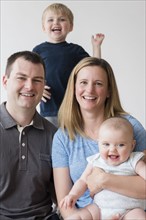 Portrait of parents with son (2-3) and baby daughter (12-17 months)