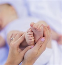 Mother holding baby boy 's (6-11 months) feet