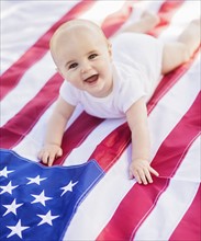 Baby boy (6-11 months) lying on American flag