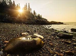 Rocks and pebbles on beach at sunrise