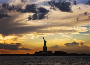 Silhouette of Statue of Liberty at sunset