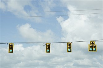 Road signals on cable against cloudy sky