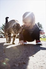 Crouching girl (2-3) and cat
