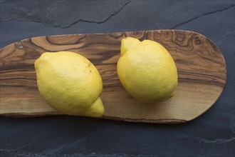 Two lemons on wood board
