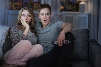 Young couple watching TV at night.
