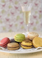 Macaroons on plate with champagne in background.