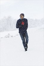 Mid adult man walking on snow. New York City, New York, USA.