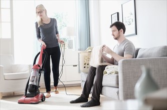 Couple cleaning living room.