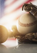 Close-up of baseball glove, ball and bat.