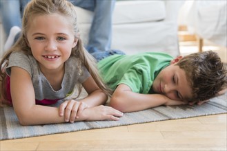 Boy and girl (6-7, 8-9) lying on floor