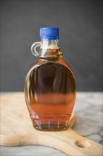 Maple syrup in bottle on cutting board