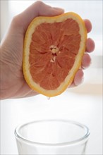 Woman's hand squeezing grapefruit
