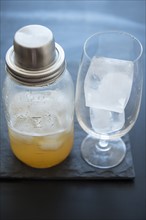 Ice cubes in drinking glass and cocktail shaker