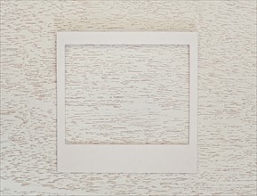 Empty Polaroid frame on textured wood