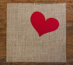 Linen cloth with textile heart shape on table