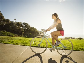 Young woman cycling in park