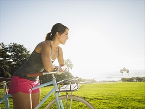 Young woman with bicycle in park