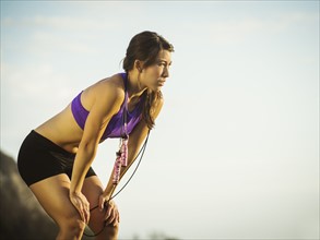 Young woman with jump rope resting