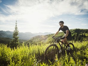 Man during bicycle trip in mountain scenery