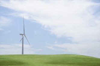 Wind turbine in field on sunny day