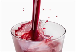 Fresh red juice being poured into glass