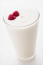 Yogurt with raspberries in drinking glass