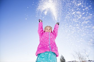 Girl (10-11) playing with snow