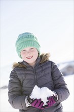 Girl (8-9) holding snow