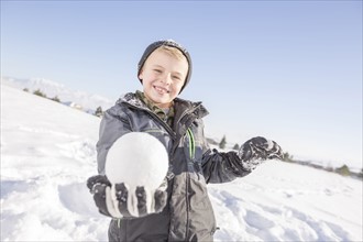Portrait of boy (8-9) holding snowball
