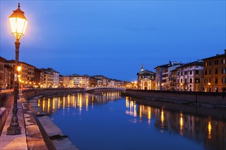 Illuminated townhouses by Arno river at night