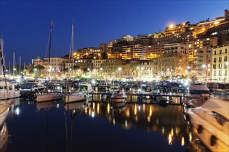 Boats in city marina at night
