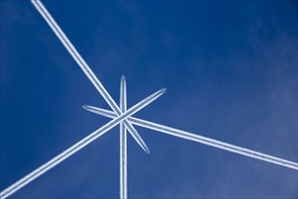 Crossed vapor trails of airplanes in blue sky