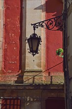 Ornate street light against red wall