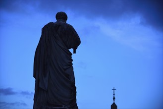 Statue of St. Peter against sky at dusk
