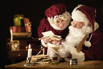 Santa and Mrs. Claus reading child's letter.