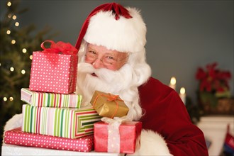 Portrait of Santa Claus holding Christmas presents.