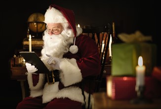 Santa Claus using digital tablet.